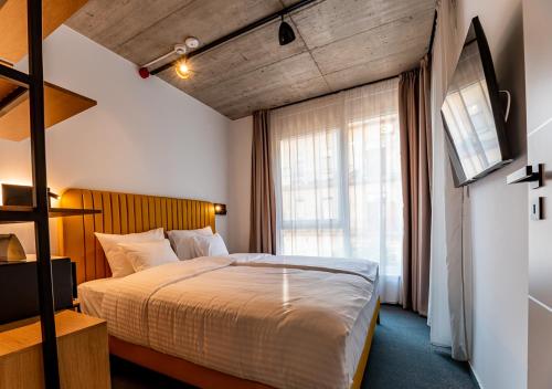 a bedroom with a large bed and a window at Noir Hotel in Szeged