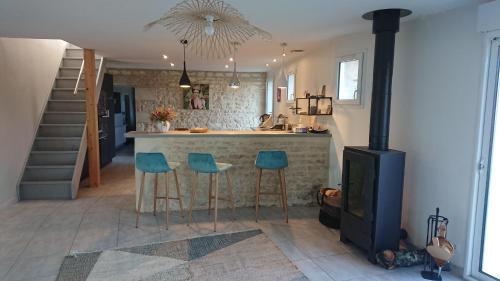 a kitchen with a bar with two stools and a stove at Chambre cosy in Niort