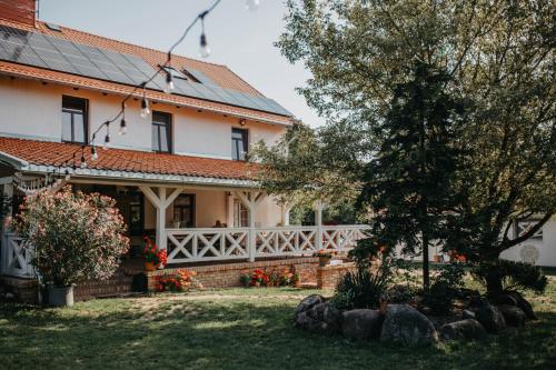 a house with a white fence and a tree at Kosowisko in Miłki
