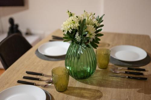 a green vase with white flowers sitting on a table at Napa Centrale Suites in Ayia Napa
