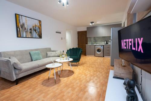 een woonkamer met een bank en een flatscreen-tv bij Napa Centrale Suites in Ayia Napa