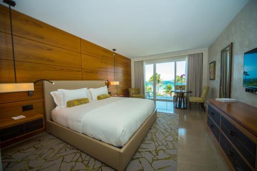 um quarto com uma cama grande e uma janela grande em Royal Blues Hotel em Deerfield Beach