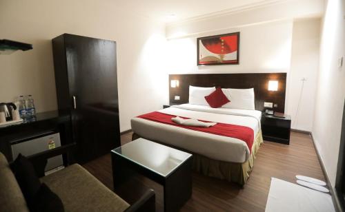 a hotel room with a bed with a red blanket at ANR Hotels in Lucknow