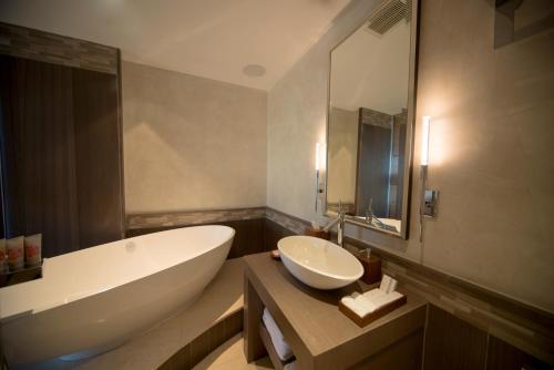 a bathroom with a white tub and a sink at Royal Blues Hotel in Deerfield Beach