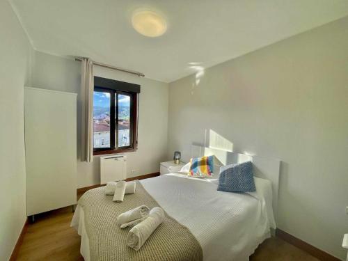 een slaapkamer met een bed met handdoeken erop bij Ostadar etxea Centrico apartamento reformado in Bermeo
