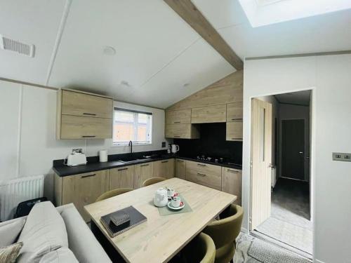 a small kitchen with a table and a couch at Wag Tail Lodge with Hot Tub in Barmby on the Moor