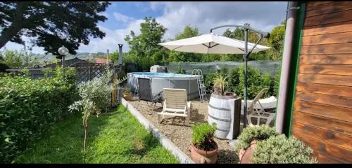 a patio with an umbrella and chairs and a table at CHALET IL GELSOMINO DELL'ETNA in Giarre