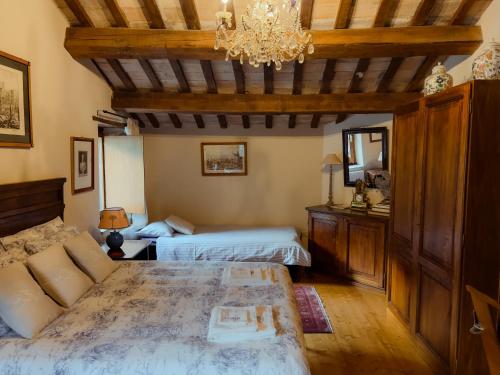 a bedroom with two beds and a chandelier at Farmhouse La Siesta in Treia