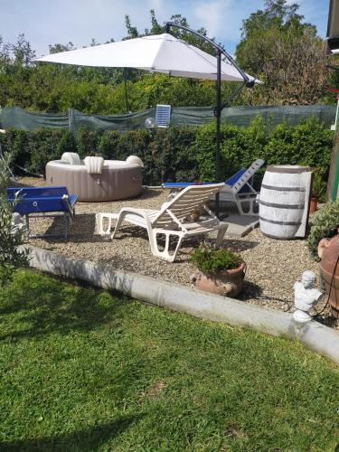 a yard with lounge chairs and an umbrella at CHALET IL GELSOMINO DELL'ETNA in Giarre