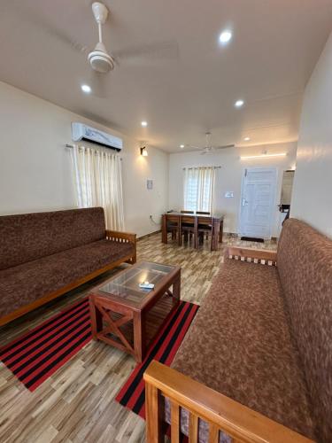 - un salon avec deux canapés et une table dans l'établissement SANTA MARIA HOSTEL MUNROE ISLAND, à Munroe Island