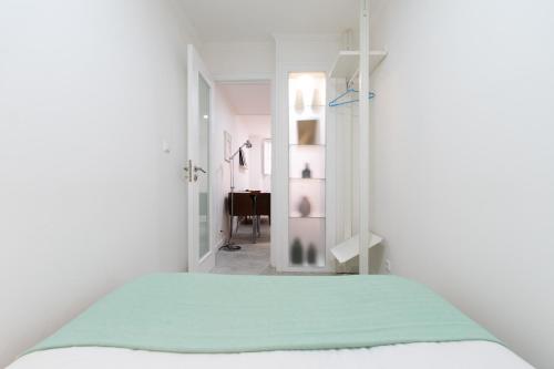 biały pokój z łóżkiem i lustrem w obiekcie TravelingToLisbon 98 - Alfama w Lizbonie