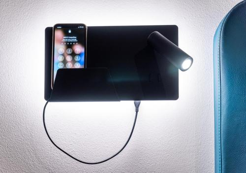 an iphone is plugged into a wall charger at Noir Hotel in Szeged