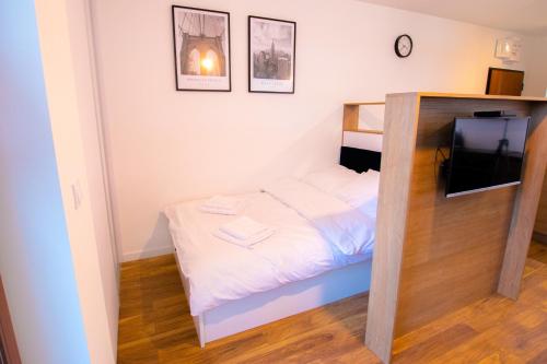 a small bedroom with a bed and a television at High Standard studio. City Center. Free parking. in Warsaw