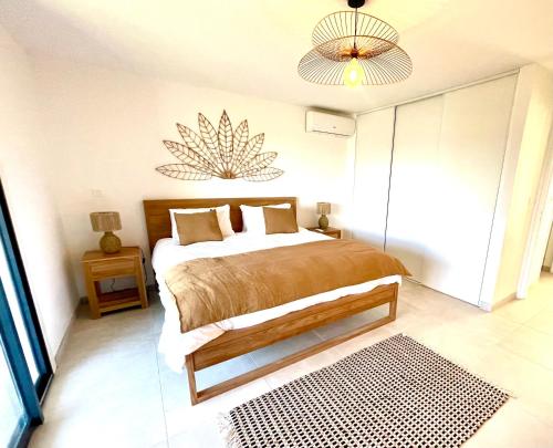 a bedroom with a bed and a chandelier at Cottage Sable et Soleil in Anse Marcel 