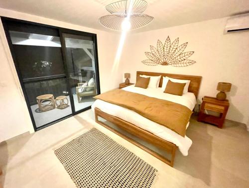 1 dormitorio con cama y ventana grande en Cottage Sable et Soleil, en Anse Marcel 