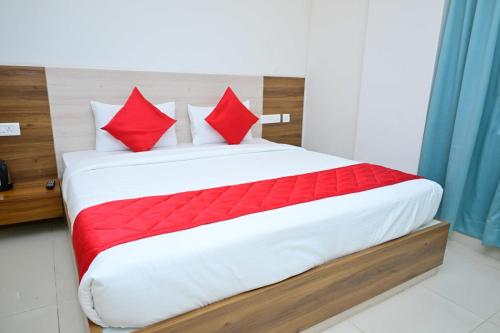 sypialnia z dużym łóżkiem z czerwonymi poduszkami w obiekcie V.R.B Lodging and Boarding w mieście Dod Ballāpur