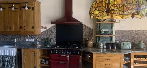 eine Küche mit einem roten Herd Top-Backofen in der Unterkunft The Chamberet Grand Coeur in Chamberet