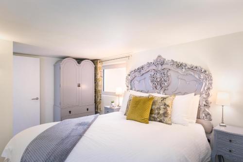 - une chambre avec un grand lit blanc et une tête de lit bleue dans l'établissement Gorgeous Boutique Flat Sleeps 2 in Lyme Regis, à Lyme Regis