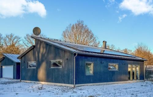 a blue house with snow on the ground at Awesome Home In Rockneby With Kitchen in Rockneby