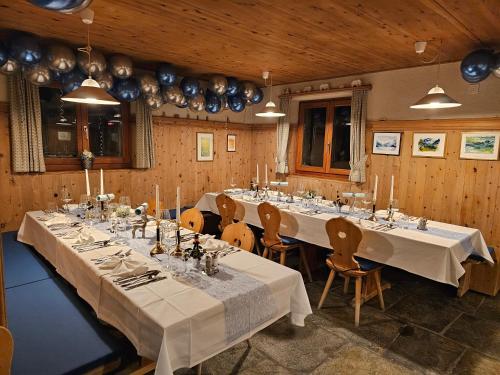 a large room with long tables and chairs at Hotel Ristorante Lagrev in Maloja