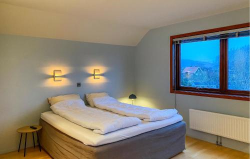 1 dormitorio con 1 cama con sábanas blancas y ventana en 2 Bedroom Awesome Home In lesund en Ålesund