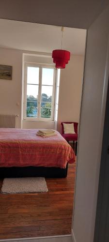 a bedroom with a red bed and a window at Studio à la Petite Boissière proximité des plages et de la gare SNCF in Pluguffan