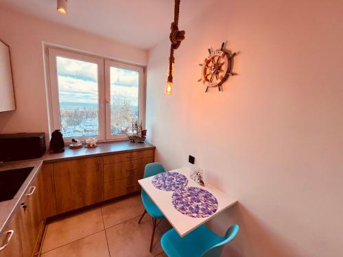 eine Küche mit einem Tisch und Stühlen sowie einem Fenster in der Unterkunft Apartament Karlikowska z widokiem na morze in Sopot