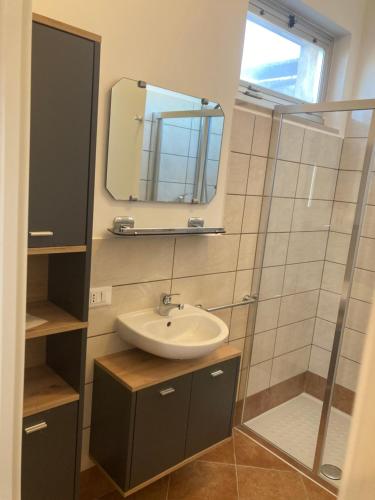 een badkamer met een wastafel en een spiegel bij Attico Verdi in Gorizia