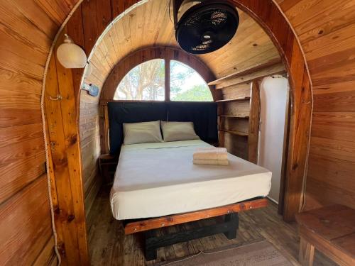 a bed in a tiny house with a round window at Machete WING SURF KITE & FOIL in Punta Chame