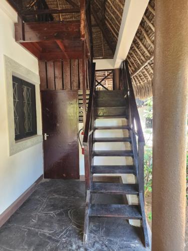 a staircase leading to a room with a door at Karibuni, Villa 107, Beachfront Stay with Restaurant, Pool & Bar in Malindi