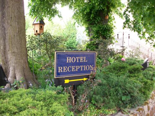 a blue hotel reception sign in a garden at Santo's Higham Farm Hotel in Alfreton
