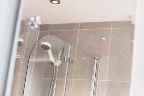 a shower with a blow dryer in a bathroom at *3Bed House Central location Free Parking Perfect for contractors & groups Managed by Chique Properties Ltd in Great Linford
