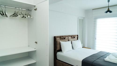 Schlafzimmer mit einem Bett mit weißen Wänden und einem Fenster in der Unterkunft Port Marmaris Rooms in Marmaris