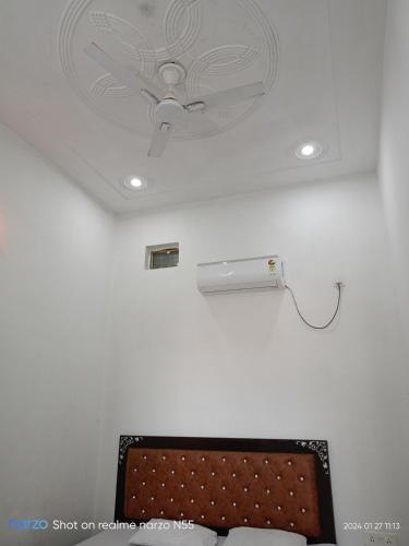 a ceiling with a ceiling light and a ceiling fan at Shri radhe shyam sadan in Govardhan