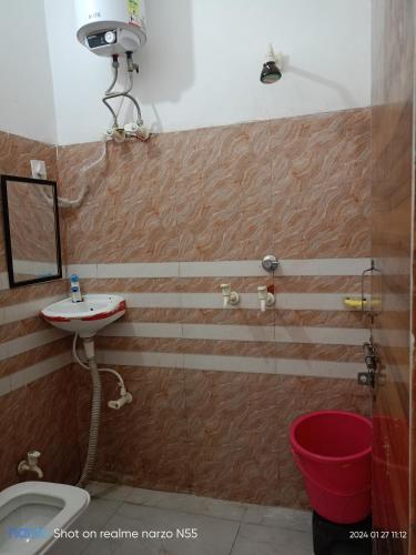 a bathroom with a sink and a toilet and a mirror at Shri radhe shyam sadan in Govardhan