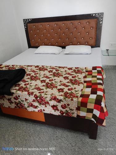 a bedroom with a bed with a flower quilt at Shri radhe shyam sadan in Govardhan