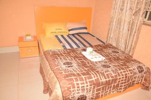 a bedroom with a bed with a comforter on it at SEE NEW HOTEL in Nsukka