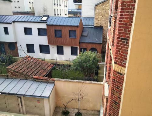 an aerial view of a group of buildings with roofs at Sunny Serenity: 2-room Charm in Boulogne in Boulogne-Billancourt