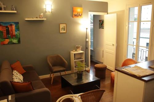 a living room with a couch and a table at Sunny Serenity: 2-room Charm in Boulogne in Boulogne-Billancourt