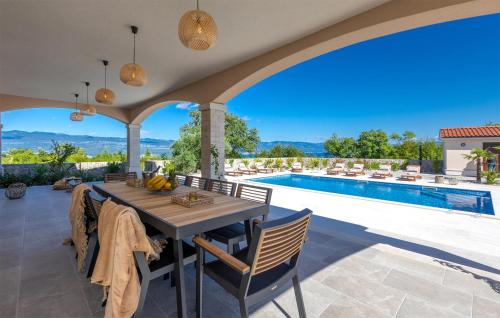 a patio with a table and chairs and a swimming pool at Lovely Home In Zestilac With Sauna in Gostinjac