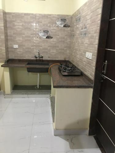 a kitchen with a sink and a stove at Kushi guest house in Bangalore