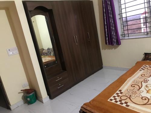 a bedroom with a mirror and a wooden cabinet at Kushi guest house in Bangalore