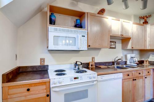 a kitchen with white appliances and wooden cabinets at River Run Village by Keystone Resort in Keystone
