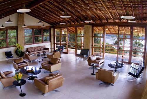 a large lobby with chairs and tables and windows at Santa Clara Hotel in Paraty