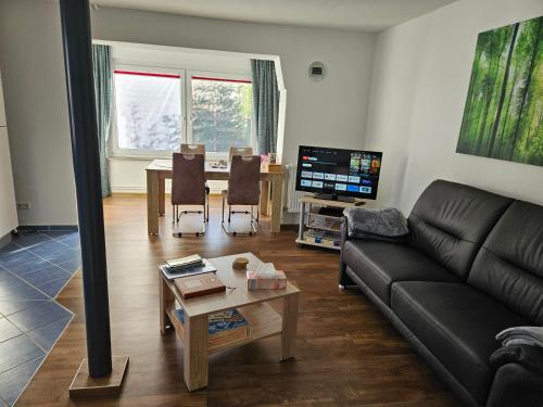 ein Wohnzimmer mit einem Sofa und einem Tisch in der Unterkunft Anbau in Evestorf