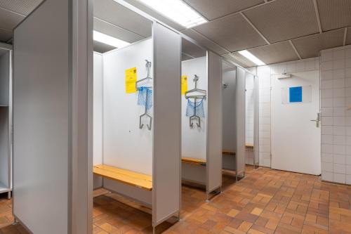 a hallway with white stalls in a restroom at Bodensee Loft - 116 m² Traumwohnung in Uhldingen-Mühlhofen