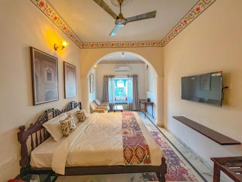 a bedroom with a large bed and a flat screen tv at DYORE House in Jaipur