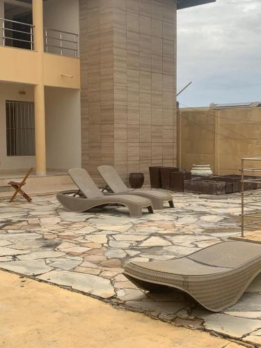 VIRASSOL Praia Hotel في سلفادور: مجموعة من الكراسي على فناء حجري