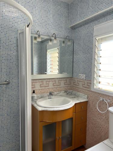 ein Bad mit einem Waschbecken und einem Spiegel in der Unterkunft Almenara Beach in Almenara