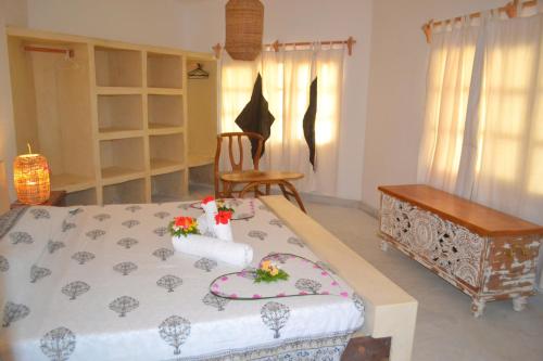 a bedroom with a bed with flowers on it at Aquarius Club in Watamu